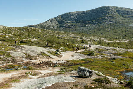 VESTLAND COUNTY, NORWAY - JULY 26, 2019: Hikers walk on the rock formation on the hiking route to Trolltungaのeditorial素材