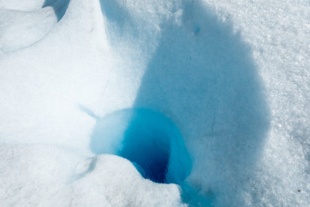 Close-up of a whole inside the snowy ice of Perito Moreno Glacier