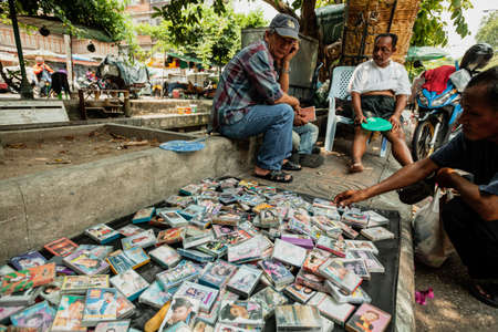 BANGKOK, THAILAND - APRIL 23, 2016: A man chooses a cassette from the street market stalのeditorial素材