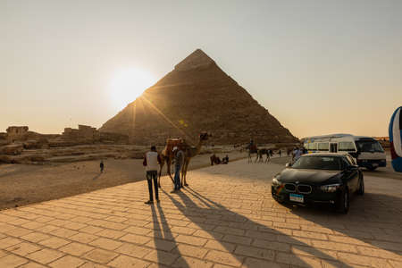 CAIRO, EGYPT- NOVEMBER 17, 2018: Vehicles, people and camels near pyramids of Gizaのeditorial素材