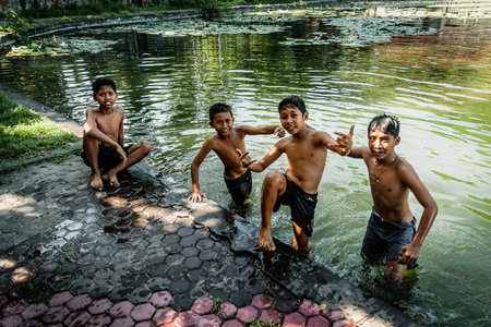 BALI, INDONESIA - MARCH 2, 2014: Children posing at the pondのeditorial素材