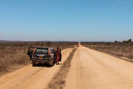AMBOSELI NATIONAL PARK - SEPTEMBER 17, 2018: A Maasai tribalman talks to a driver on the roadのeditorial素材