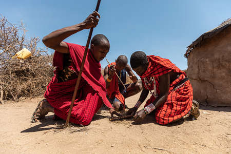 AMBOSELI NATIONAL PARK - SEPTEMBER 17, 2018: Maasai warriors making fire without the aid of matchesのeditorial素材