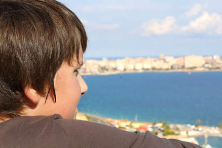 Standing boy on the background of the seascape .の写真素材