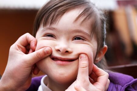 Portrait of girl with hands that make a smileの写真素材