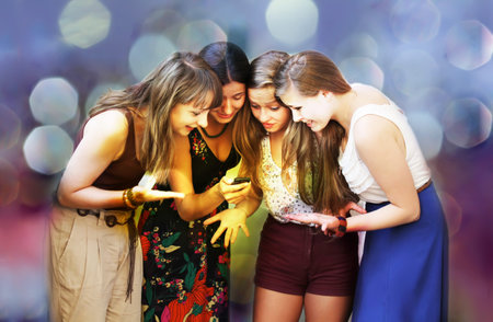Beautiful student girls looking message on mobile phone