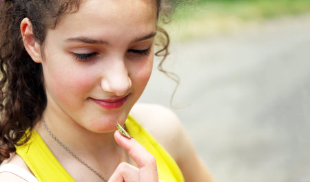 Girl looking at the grasshopper on the fingerの写真素材