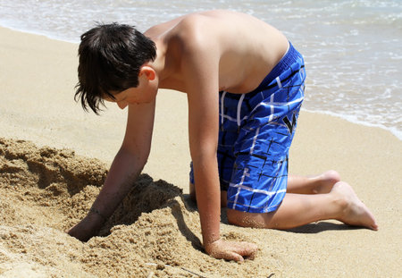 Kid on beach playing in sandの写真素材