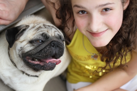 Girl with a cute mops dogの写真素材