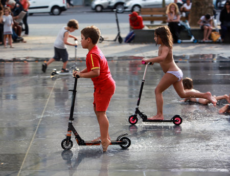 PARIS, FRANCE - SEP 07: Kids rides on scooters among fountains of Republic Square on weekend on sep 07. 2014 in Paris, Franceのeditorial素材