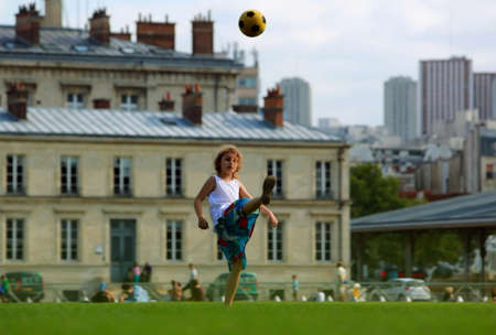 Girl playing football in front the school building in the first school dayのeditorial素材