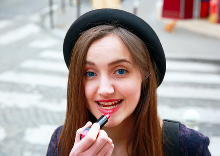 Close-up portrait of beautiful woman with pomade in the cityの写真素材