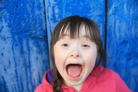 Young girl smiling on background of the blue wallの写真素材