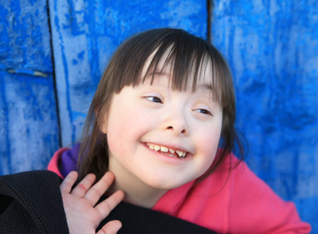 Young girl smiling on background of the blue wall.の写真素材