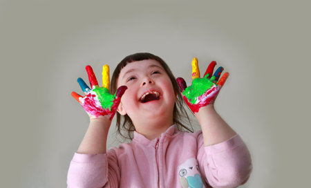 Cute little girl with painted hands. Isolated on grey background.の写真素材