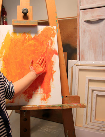 Little kid with painted hand and paintingの写真素材