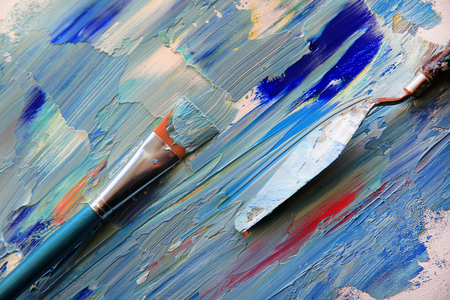 Closeup background of palette with brush and palette knifeの写真素材
