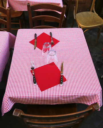 Glasses, spoons, plates and forks on the table in restaurantの写真素材