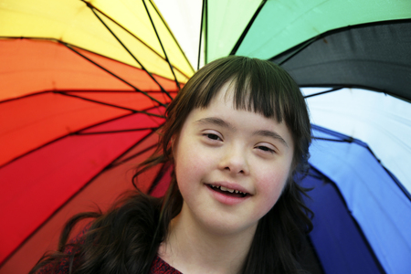 Portrait of little girl smiling on background of the umbrellaの写真素材