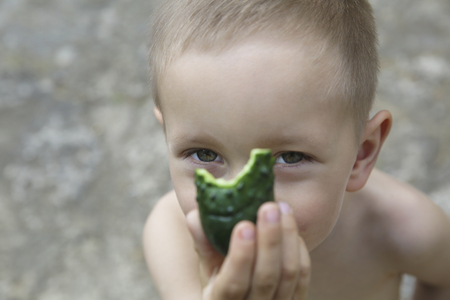 Portrait of a little boy with a cucumberの写真素材