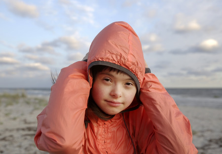 Portrait of down syndrome girl smiling on background of the seaの写真素材