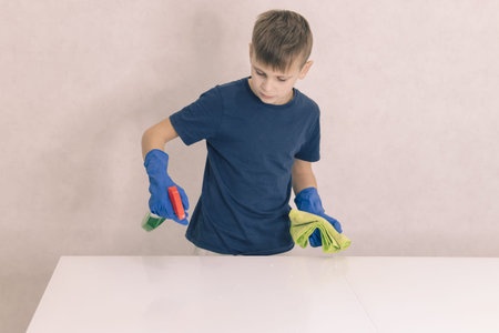 little boy cleans the glass table in the house