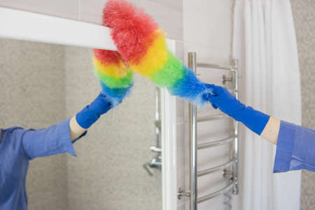 girl washing mirror with colored rag at home.House cleaning conceptの写真素材