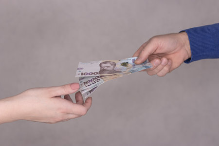 hands giving money isolated on gray background.Finance concept.の写真素材