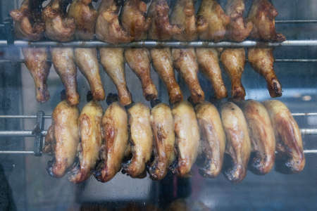 chicken legs are fried in a shop window for sale to hungry peopleの写真素材