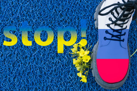 boot the flag of Russia steps on yellow flowers on blue background,war