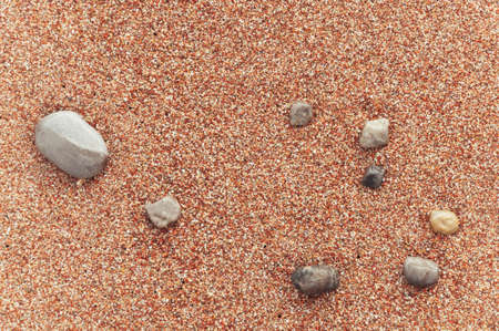 beach with yellow sand close-up, beautiful stones in the frameの写真素材