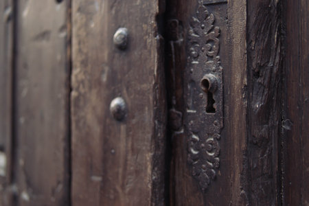 brown wooden antique door with a metal lock close-up, there is a place for an inscriptionの写真素材