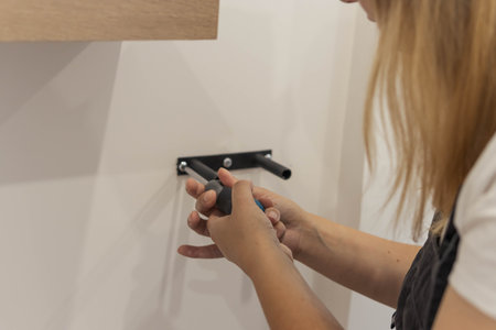 the girl spins the shelf for books on the wall. the girl is turned back to the camera close-up,...