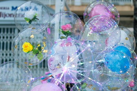 a lot of multi-colored Balloons close-up on the street, a lot of balls inside them are roses and multi-colored sparkles. there is a place for an inscriptionの写真素材