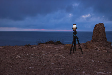 the phone on a tripod stands at dawn on a mountain by the sea and photographs the dawn. Beautiful...
