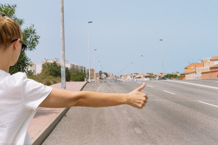 A young woman catches a car on the road close-up on her hand, automatic stop, automatic brakingの写真素材