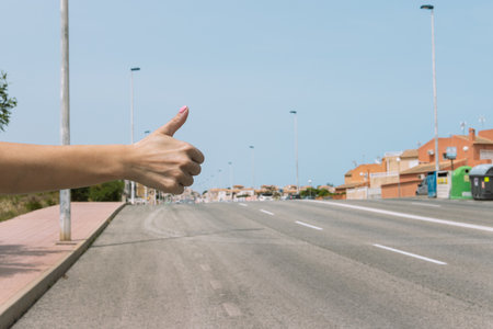 female hand close-up raised finger up, a young girl stops the car,の写真素材