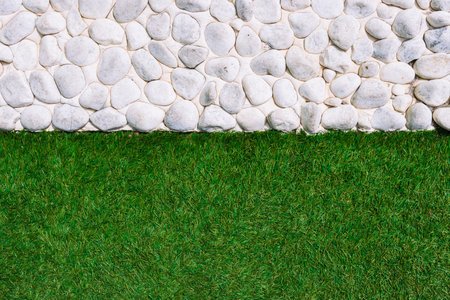 background green grass and a fence with white stone,there is a place for an inscriptionの写真素材