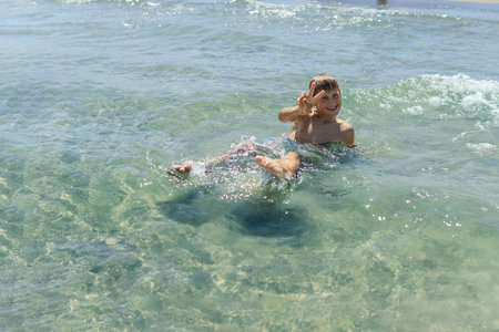 Happy boy swims and dives underwater. water sports and activities with parents on summerの写真素材