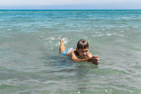 a boy in the sea learns to swim.the concept of summer holidays,summer landscape with a childの写真素材