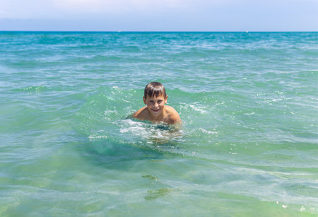 Happy boy swims and dives underwater. water sports and activities with parents on summerの写真素材