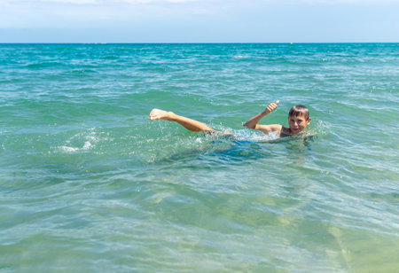 Happy boy swims and dives underwater. water sports and activities with parents on summerの写真素材