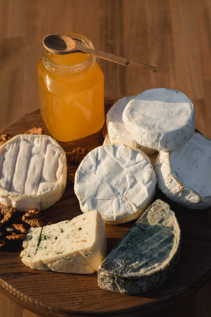 cheese plate. different cheeses on a wooden plate. cheeses of honey and nuts. Close upの写真素材