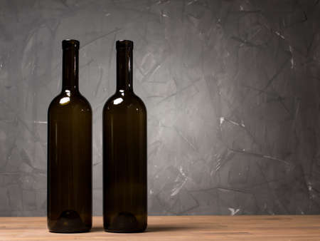 Wine bottles on the table against wooden backgroundの写真素材