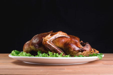 Beautiful food: baked whole duck close-up on a platter on the table. Horizontal view from aboveの写真素材