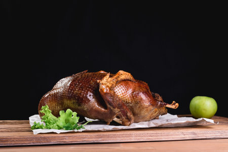 Roasted duck with apples. baked whole duck close-up on a platter on the table. Horizontal view from...