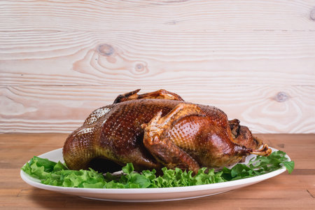 Beautiful food: baked whole duck close-up on a platter on the table. Horizontal view from aboveの写真素材