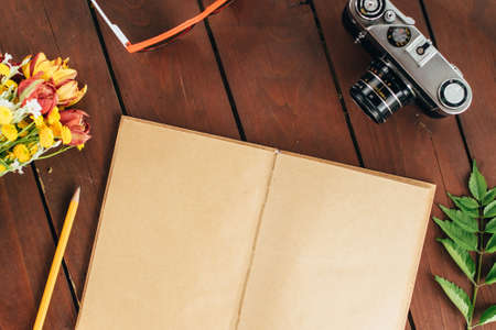 flat lay diary. Top view of notebook paper and camera on a wooden background .の写真素材