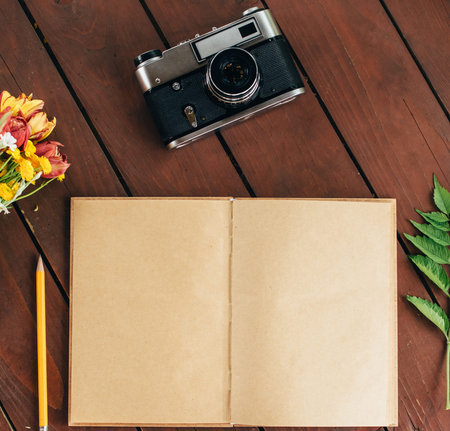 flat lay diary. Top view of notebook paper and camera on a wooden background .