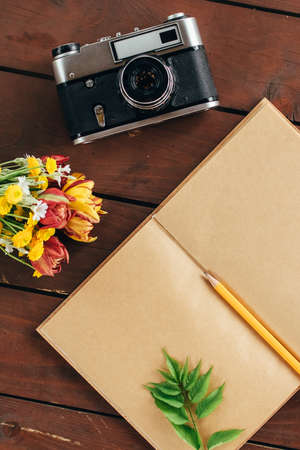 flat lay diary. Top view of notebook paper and camera on a wooden background .の写真素材